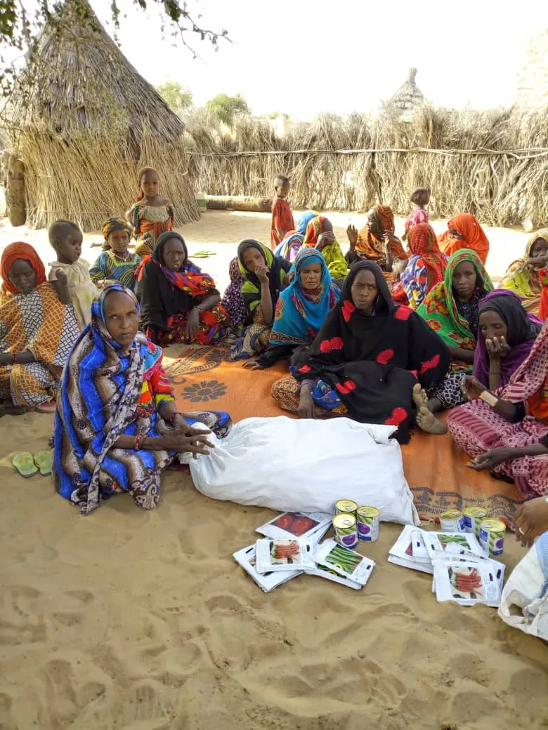 Formatrice partageant ses connaissances en maraîchage numérique avec un groupe de femmes dans un village